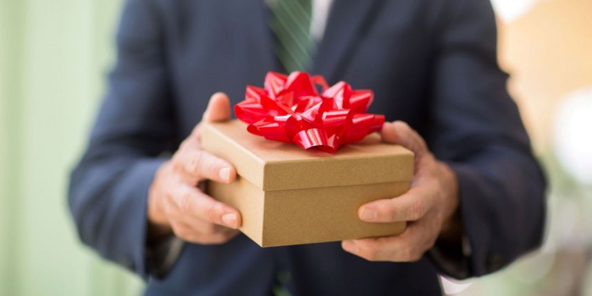 Businessman mit Geschenk in der Hand